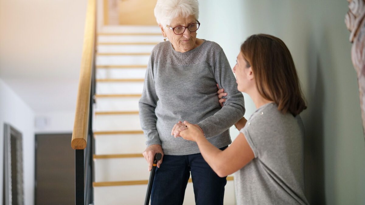 Homecare helping elderly woman going down the stairs