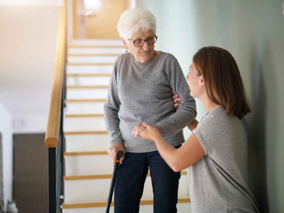 Homecare helping elderly woman going down the stairs